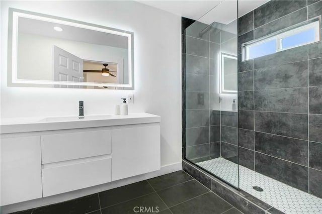 bathroom with ceiling fan, vanity, tile patterned floors, and a tile shower