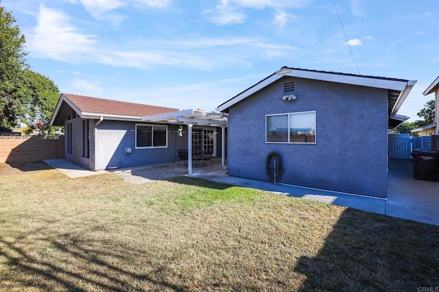 rear view of house with a lawn and a patio