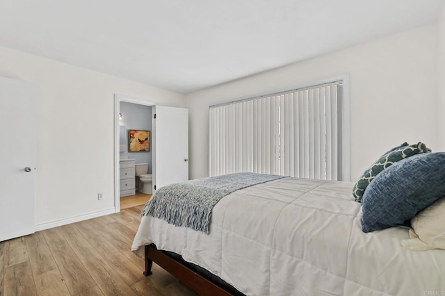 bedroom featuring ensuite bathroom and wood-type flooring