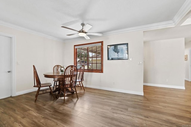 dining space featuring ceiling fan, wood-type flooring, and crown molding