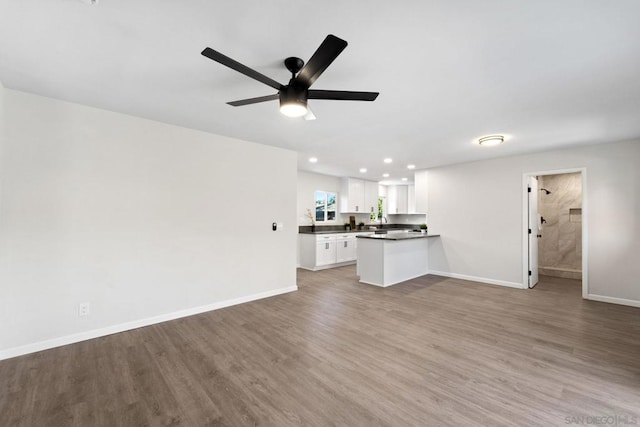 unfurnished living room with ceiling fan and hardwood / wood-style floors