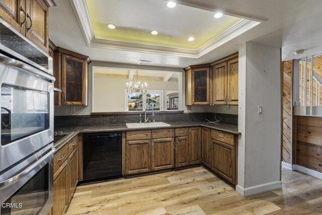 kitchen with sink, black dishwasher, a raised ceiling, and a notable chandelier