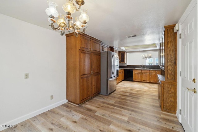 kitchen with visible vents, a notable chandelier, black dishwasher, dark countertops, and freestanding refrigerator