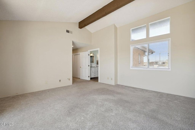 empty room with high vaulted ceiling, light colored carpet, beam ceiling, and visible vents