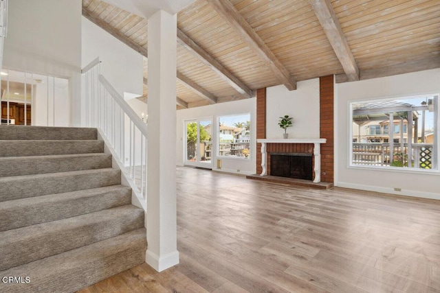 unfurnished living room featuring high vaulted ceiling, stairway, wood ceiling, wood finished floors, and beam ceiling