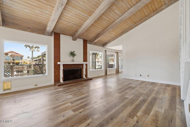 unfurnished living room featuring baseboards, a fireplace, beamed ceiling, high vaulted ceiling, and wooden ceiling