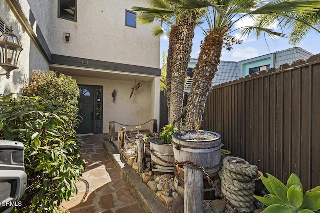 entrance to property with stucco siding and fence