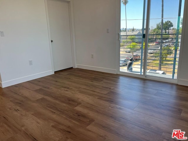 empty room with dark hardwood / wood-style floors