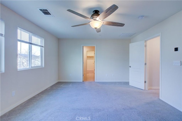 unfurnished room with visible vents, light carpet, and baseboards