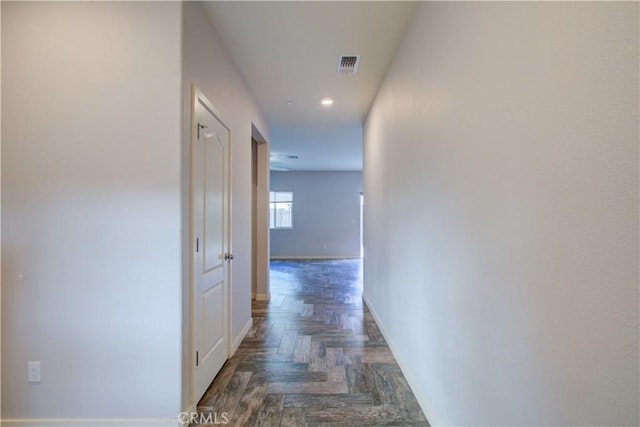 hall with visible vents and baseboards