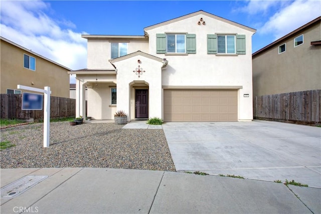 view of front of house featuring a garage, driveway, fence, and stucco siding