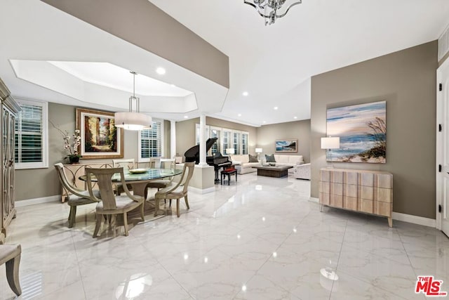 dining area with a raised ceiling