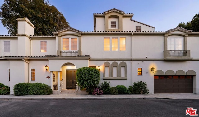 mediterranean / spanish house featuring a balcony and a garage