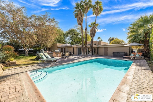 view of swimming pool with exterior kitchen, a jacuzzi, and a patio