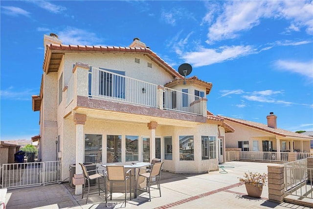 rear view of house with a patio area and a balcony