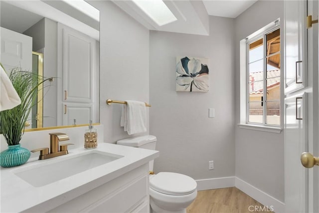 bathroom with hardwood / wood-style flooring, toilet, and vanity