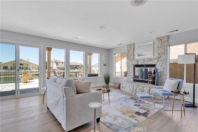 living room featuring light hardwood / wood-style flooring and a stone fireplace