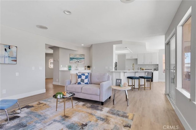 living room with sink and light wood-type flooring