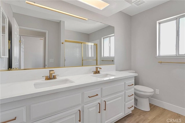 bathroom featuring a shower with shower door, vanity, toilet, and hardwood / wood-style flooring