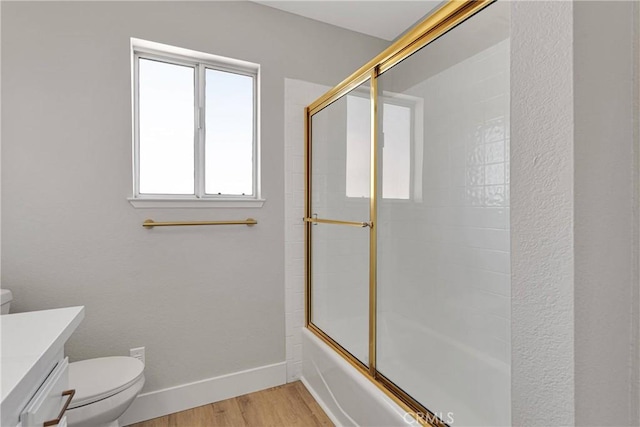 full bathroom with hardwood / wood-style flooring, enclosed tub / shower combo, vanity, and toilet