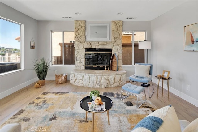 living room featuring a fireplace, plenty of natural light, and hardwood / wood-style flooring