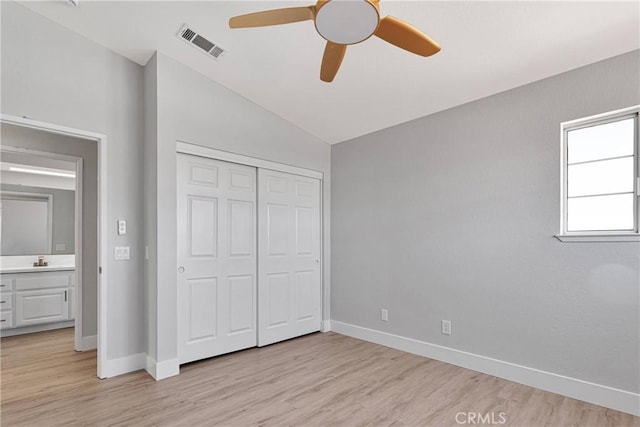 unfurnished bedroom with light hardwood / wood-style floors, sink, a closet, vaulted ceiling, and ceiling fan