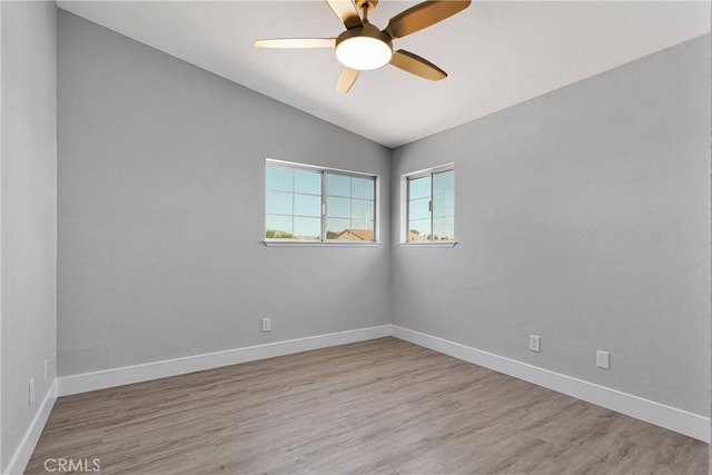 unfurnished room with lofted ceiling, ceiling fan, and light hardwood / wood-style flooring