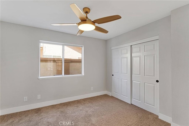 unfurnished bedroom with ceiling fan, carpet, and a closet