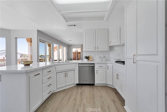 kitchen with white cabinetry, stainless steel appliances, light hardwood / wood-style floors, and kitchen peninsula