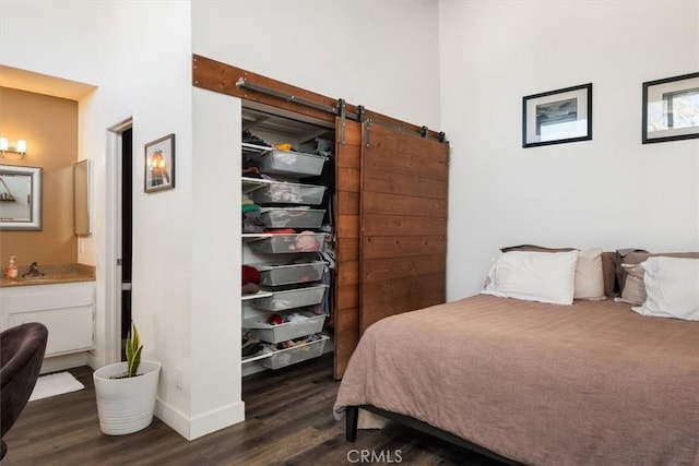 bedroom featuring dark hardwood / wood-style flooring and a barn door