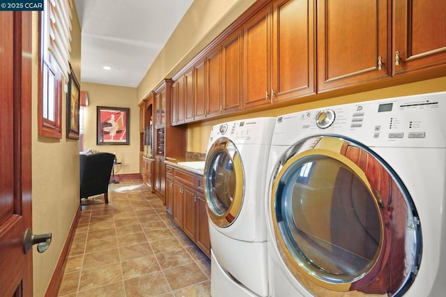 washroom featuring washing machine and clothes dryer and cabinets