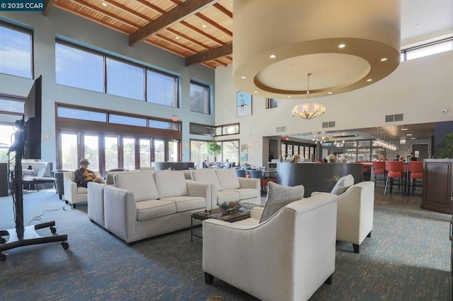 carpeted living room with a chandelier, wood ceiling, a high ceiling, and beamed ceiling