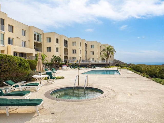 view of pool with a patio area and a hot tub