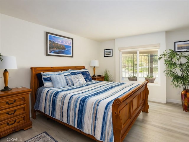 bedroom with light hardwood / wood-style floors and access to outside