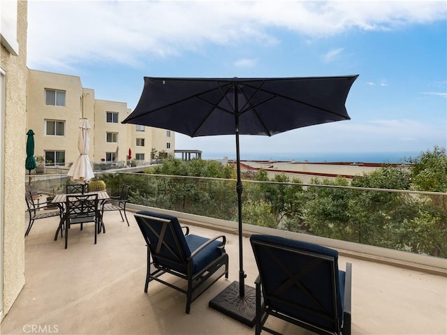 view of patio featuring a balcony and a water view