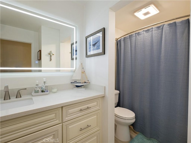 bathroom featuring toilet, vanity, and a shower with shower curtain