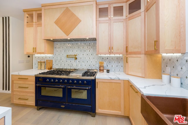 kitchen featuring double oven range, light brown cabinets, tasteful backsplash, and custom exhaust hood