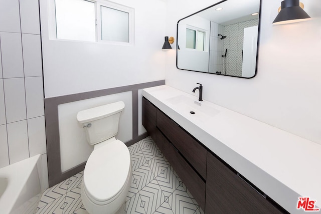 full bathroom with toilet, vanity, and tiled shower / bath