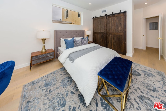 bedroom featuring hardwood / wood-style flooring, a closet, and a barn door