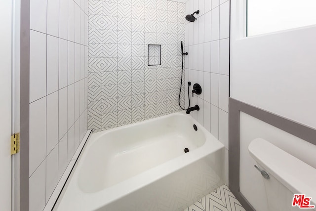 bathroom featuring toilet and tiled shower / bath combo