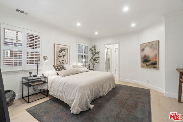 bedroom with crown molding and light wood-type flooring