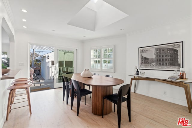 dining space featuring crown molding and light hardwood / wood-style flooring