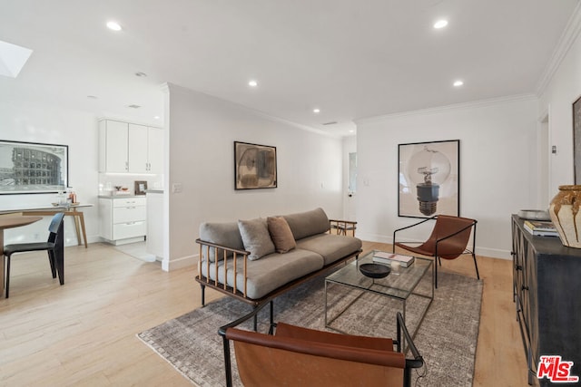 living room with a skylight, light hardwood / wood-style flooring, and ornamental molding