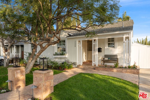 view of front of home with a front yard and a porch