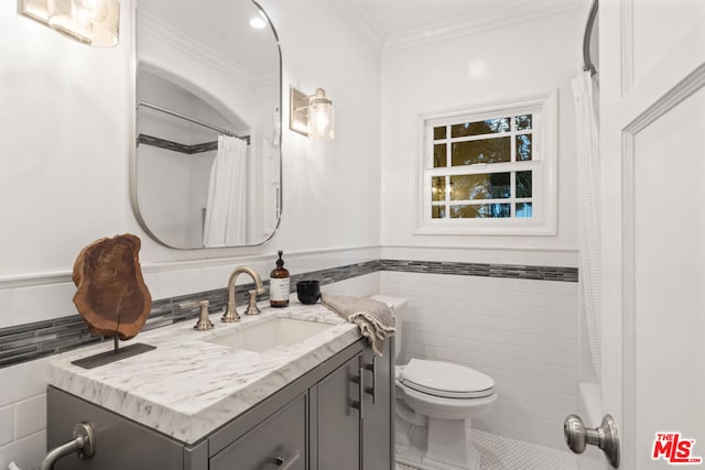 bathroom with toilet, tile walls, crown molding, vanity, and curtained shower