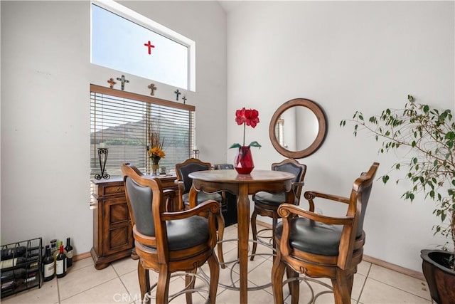 tiled dining room featuring a towering ceiling