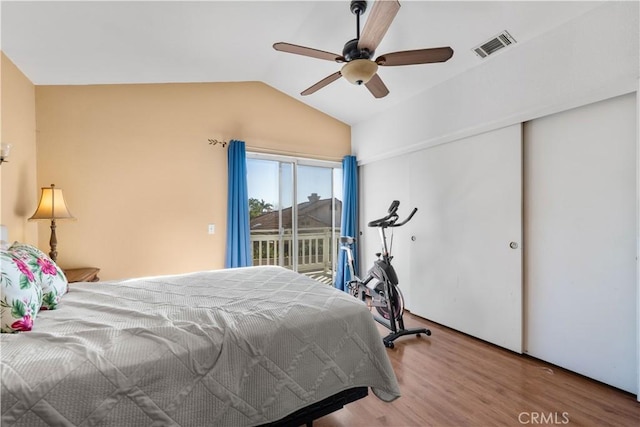 bedroom featuring ceiling fan, wood-type flooring, access to exterior, and lofted ceiling