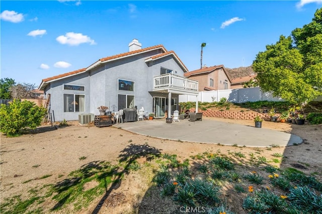 back of property featuring central air condition unit, a balcony, and a patio