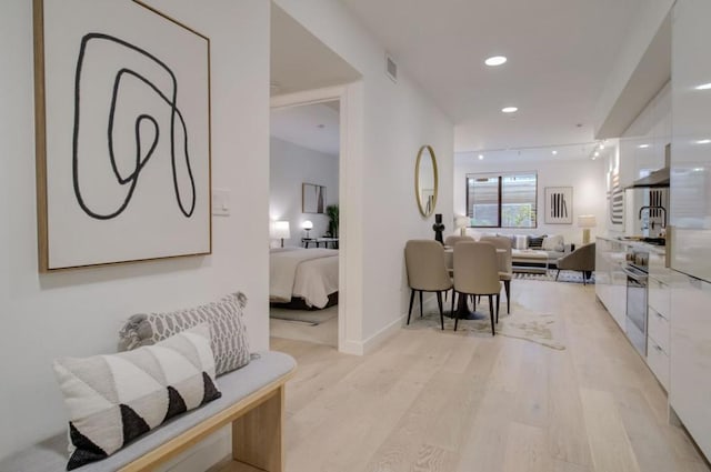 hallway with light hardwood / wood-style floors