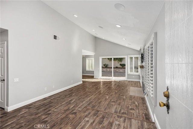 unfurnished living room featuring dark wood-type flooring and high vaulted ceiling